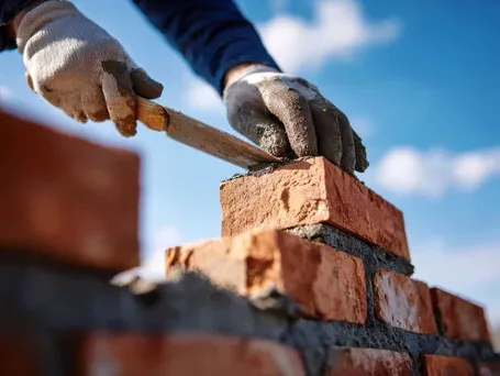 Mason setting brick in fresh mortar for a lake home project in Minnesota